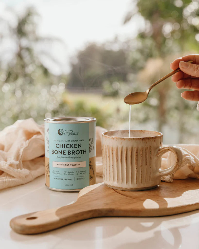 nutra organics homestyle original chicken bone broth canister with a mug of broth