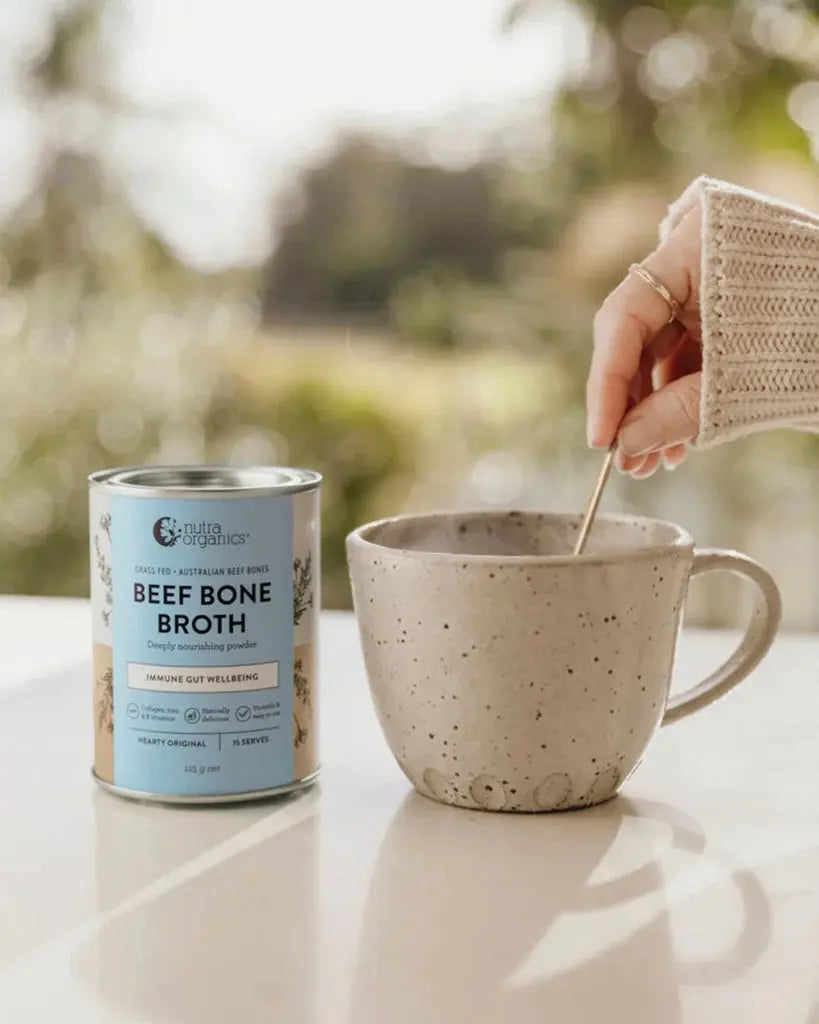 nutra orgaincs beef bone broth hearty original canister and a hot cup of broth