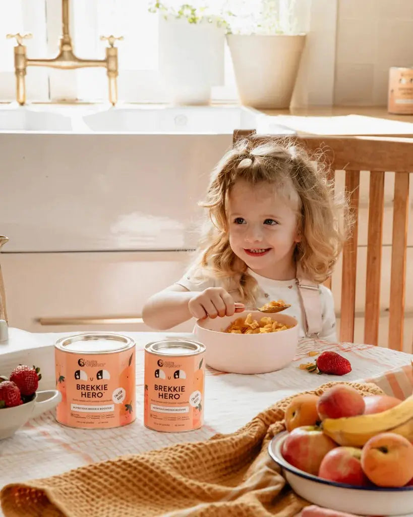 nutra organics brekkie hero canisters with a girl eating cereal