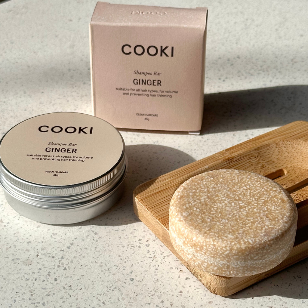 Cooki ginger shampoo bar with packaging on a light surface with box and tin