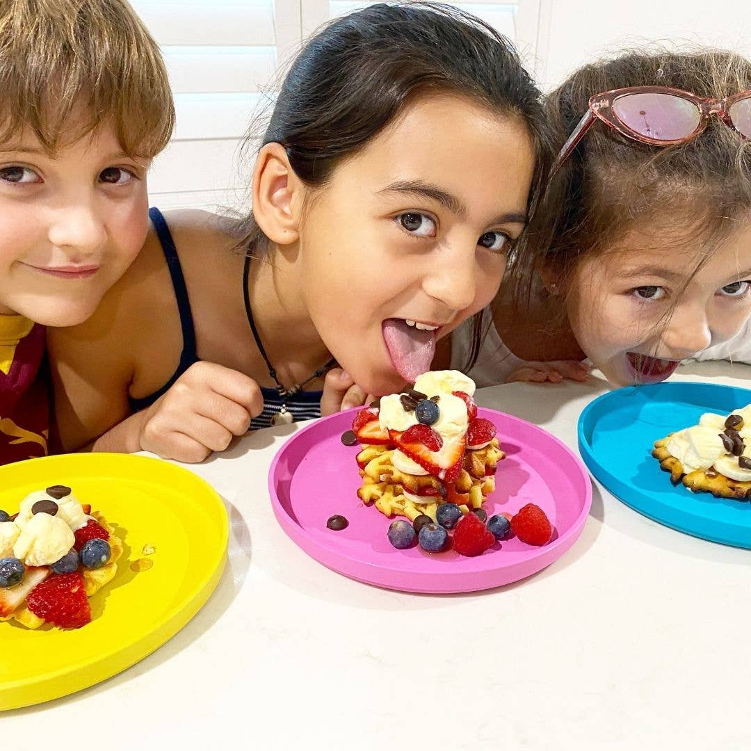 Three children enjoying waffles with fruit on colorful plates from bobo&boo