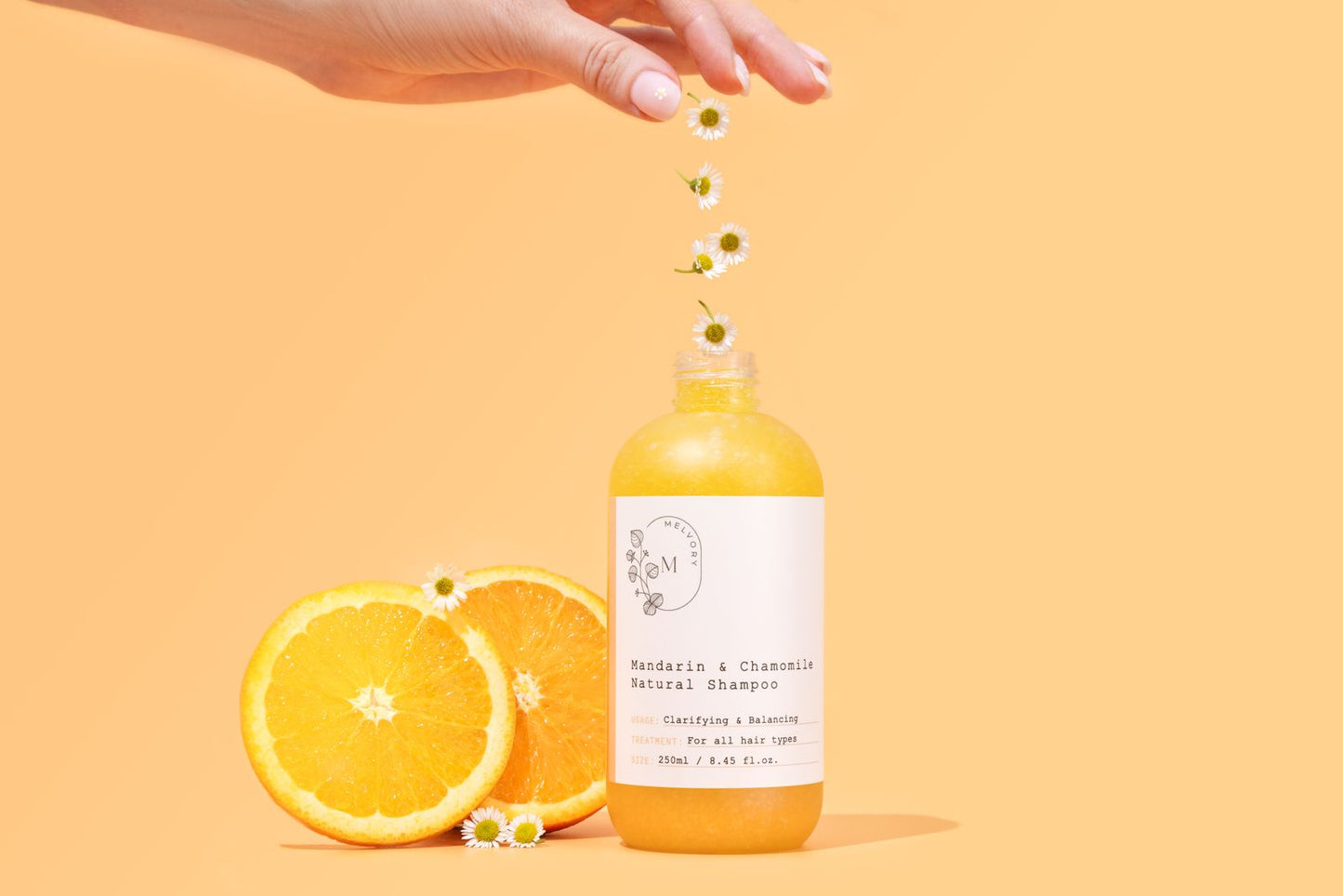 Bottle of Melvory natural shampoo with oranges and flowers on a yellow background