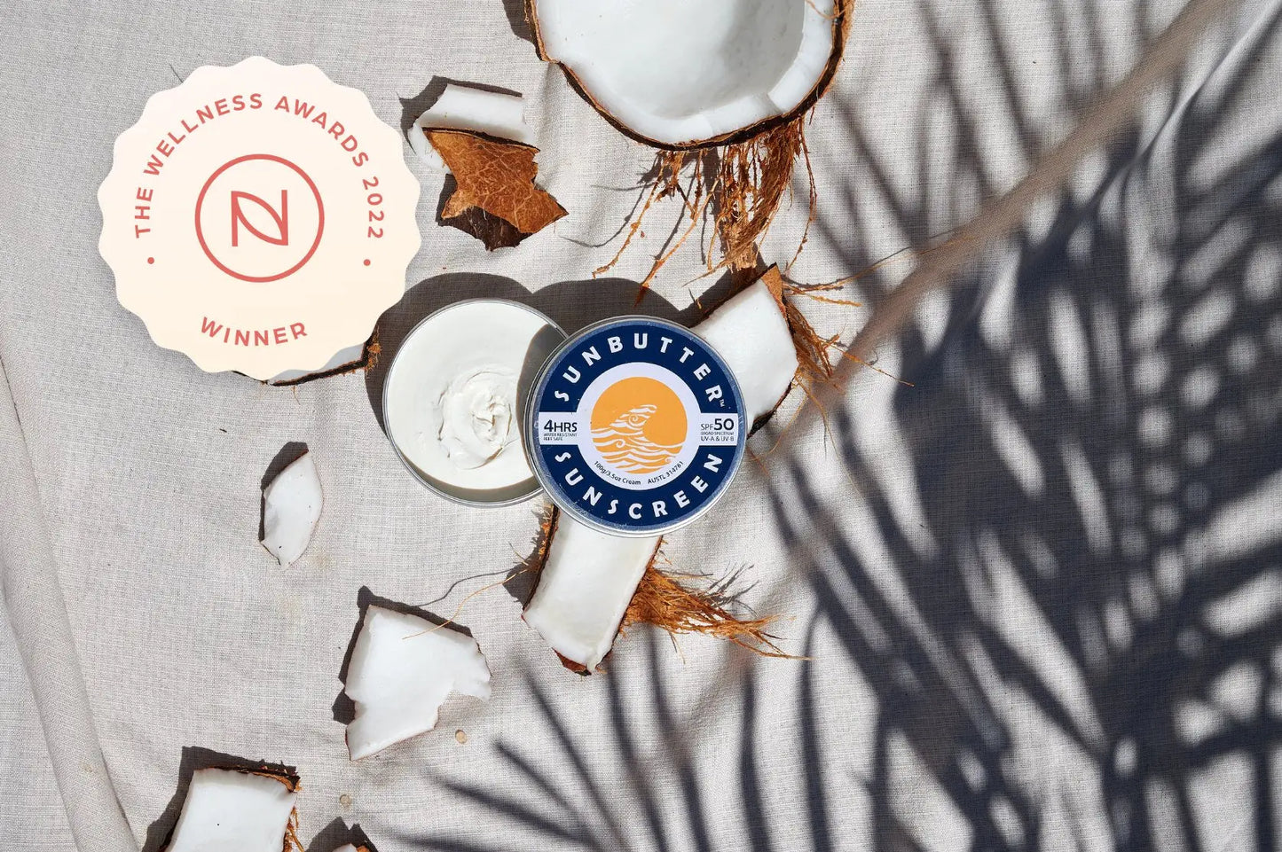 sunbutter sunscreen tin opened with coconuts and wellness award logo