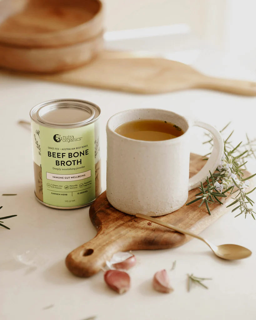 beef bone broth canister with a mug of nourishing broth