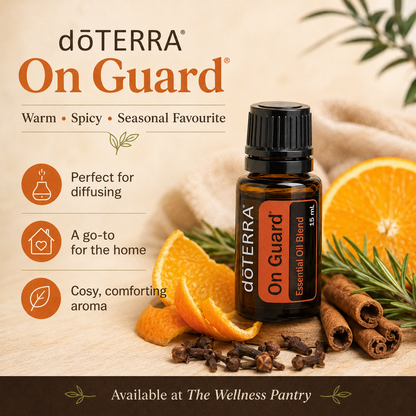 doTERRA On Guard essential oil bottle with oranges, cinnamon, and rosemary on a wooden surface.