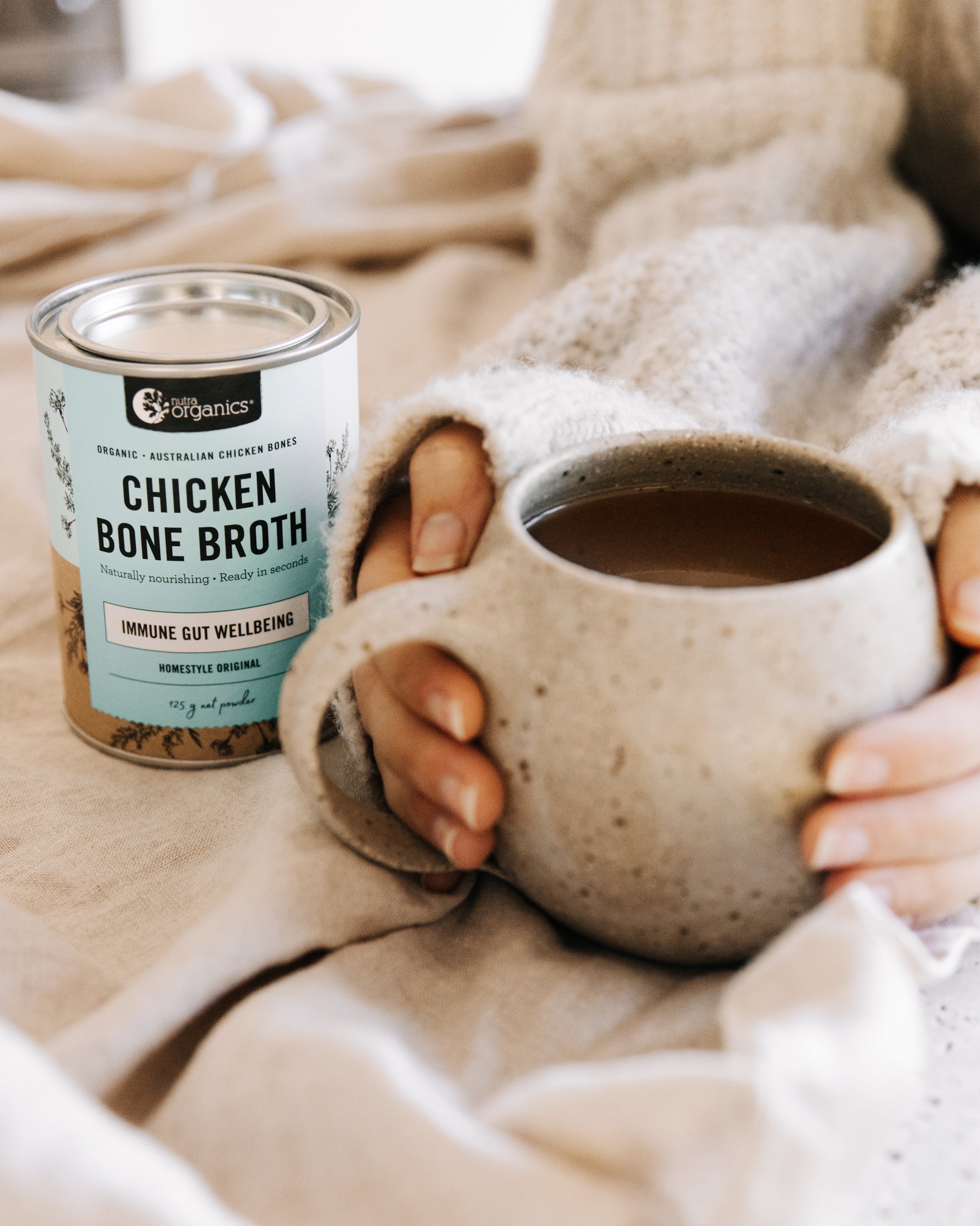 nutra organics homestyle original chicken bone broth canister with a hot cup of broth