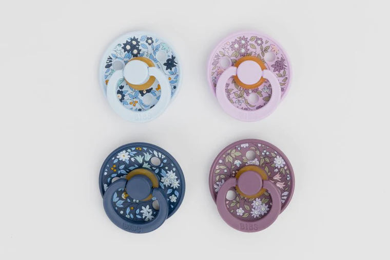 BIBS floral-patterned baby pacifiers on a light gray background