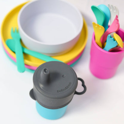 Colorful children's tableware by bobo&boo  including bowls, plates, cups, and utensils on a white background.