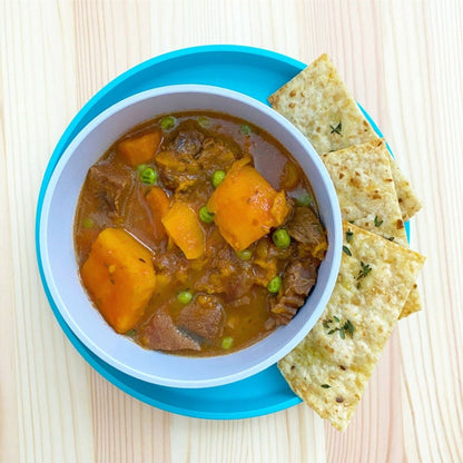 bobo&boo Bowl with beef stew with crackers on a wooden surface