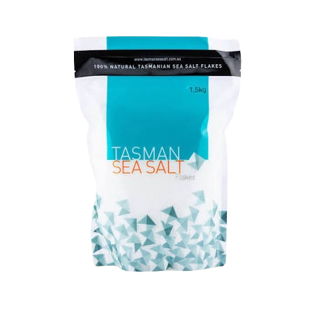 A 1.5kg bag of Tasman Sea Salt Flakes, featuring a white and teal design with a geometric pattern at the bottom, on a plain white background.