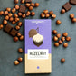 loving earth organic plant based hazlenut mylk chocolate block with hazlenuts and choclate scatter
