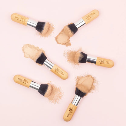 melvory Makeup brushes with powder on a light pink background