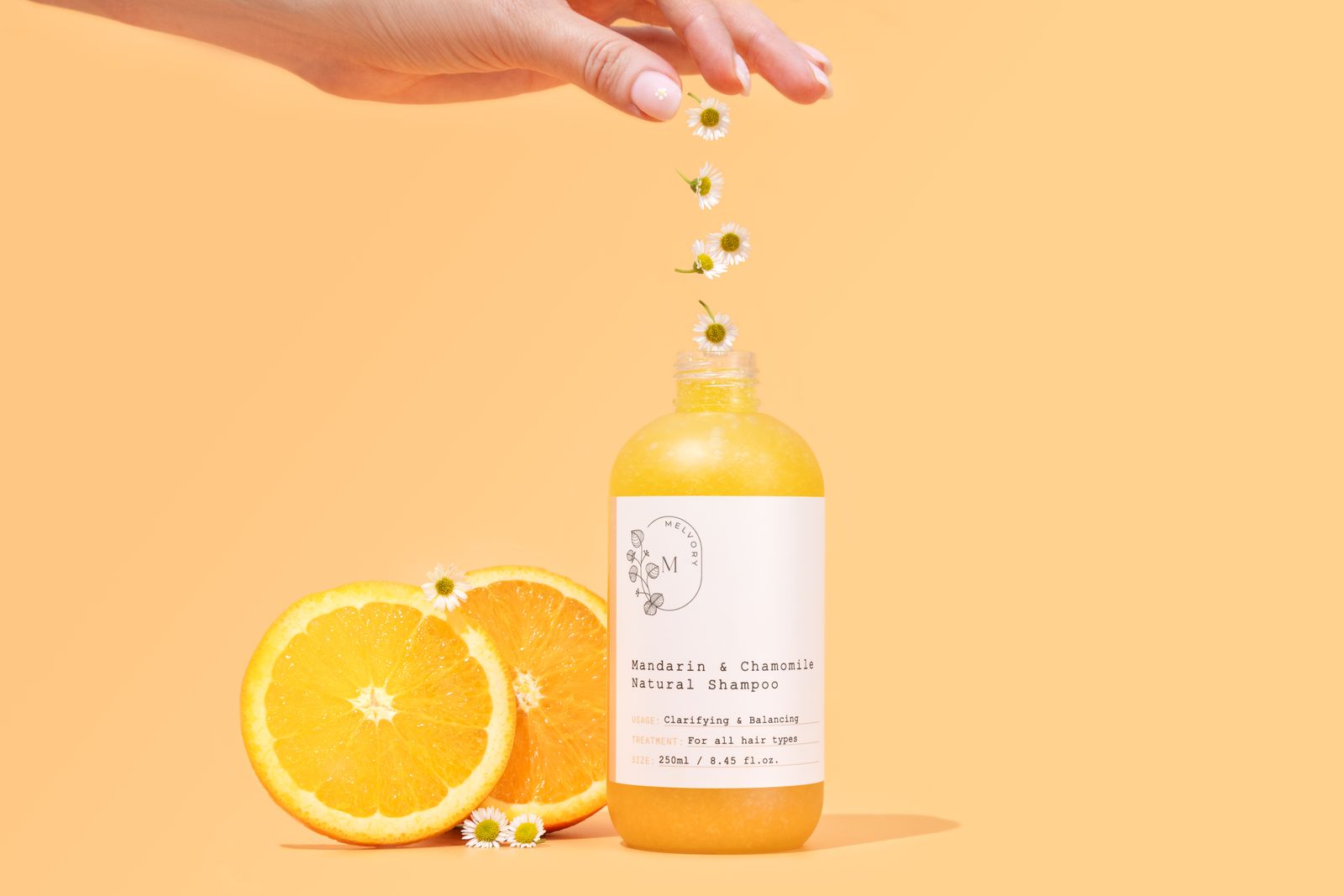 Bottle of Melvory natural shampoo with oranges and flowers on a yellow background